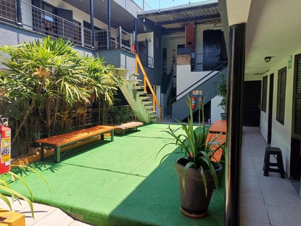 a courtyard of a building with benches and plants at Hostel El viajero in Tramandaí