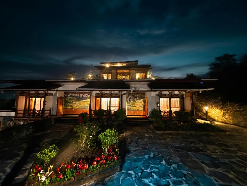 a house at night with a lit up at Yangkhil Resort in Tongsa