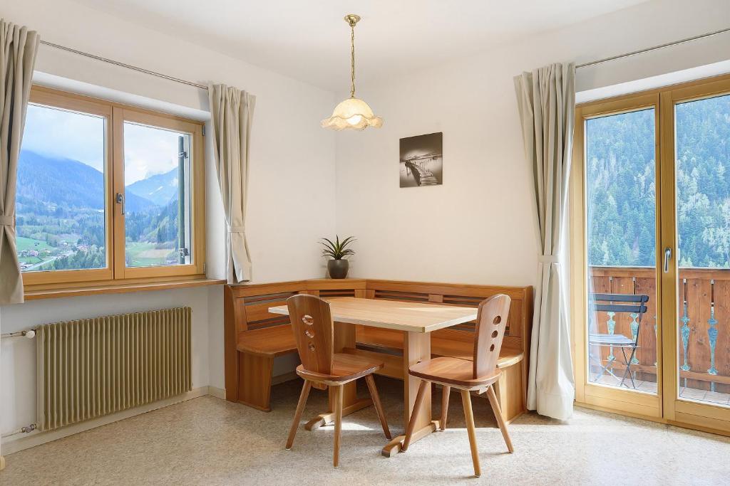 a dining room with a table and chairs and windows at Unterzerunhof 2 in Laion