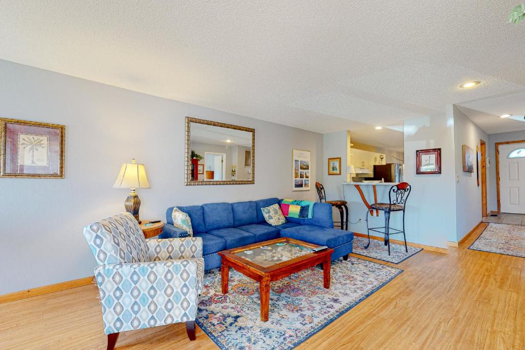 a living room with a blue couch and a table at Flip Flops Inn in Duck