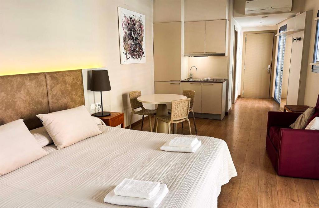 a bedroom with a bed with two towels on it at Aparthotel 1904 in Figueres