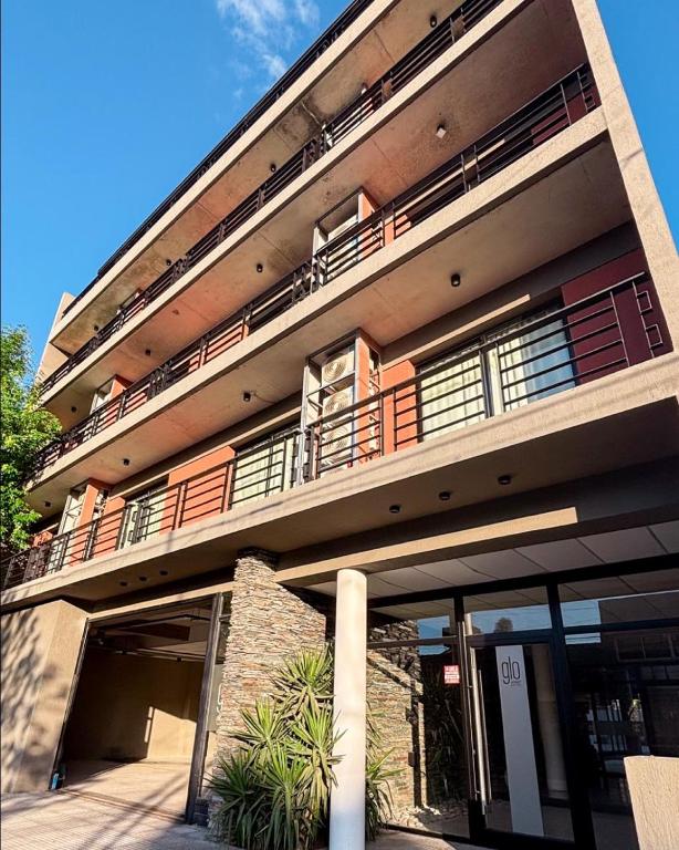 a large building with a parking garage in front of it at Glo apart hotel in Cañuelas