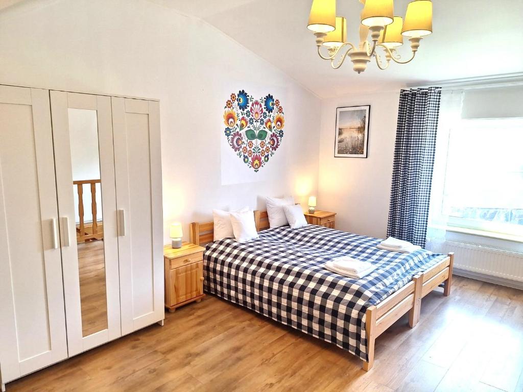 a bedroom with a bed with a checkered blanket at Pokoje Podzamcze in Stare Drawsko