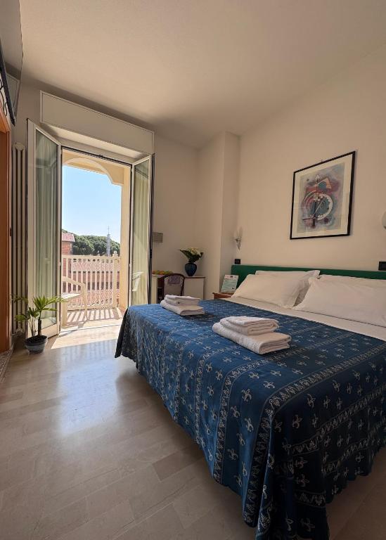 a bedroom with a bed and a balcony with a view at Hotel Kadett in Rimini