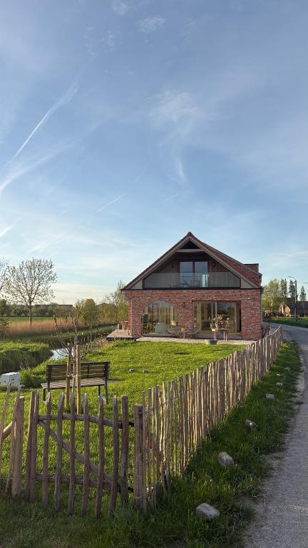 a brick house with a fence in front of it at B&B Les Trois Pignons in Diksmuide