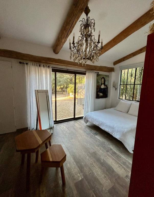 a bedroom with a bed and a chandelier at La mandarine in Ramatuelle