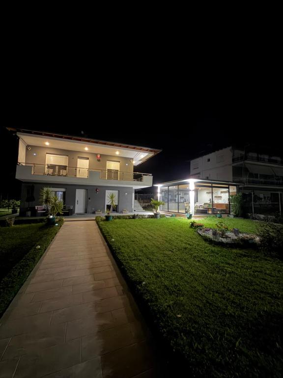a large house at night with a green lawn at Dragoti in Leptokarya