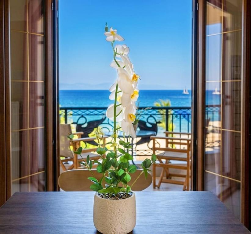 a plant sitting on a table with a view of the ocean at Kanali seaside apartment Poros 2 in Poros
