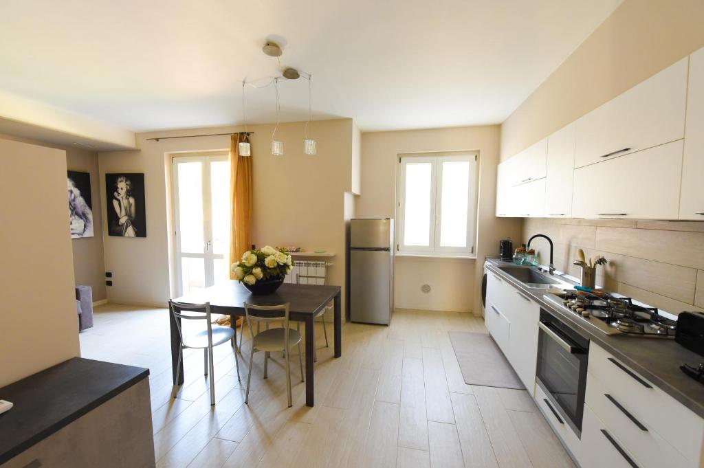 a kitchen with a table and a kitchen with white cabinets at Casa Vacanza Neris in Clusane sul Lago