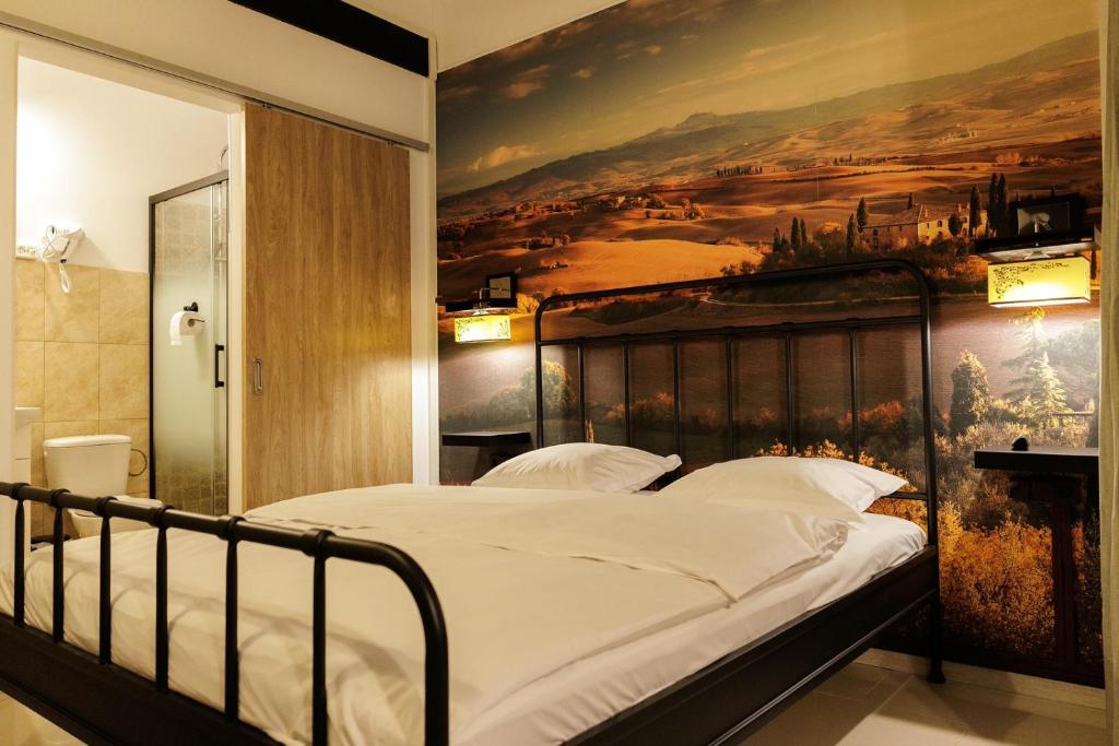 a bedroom with a large painting on the wall at Motel Remo in Lovrin
