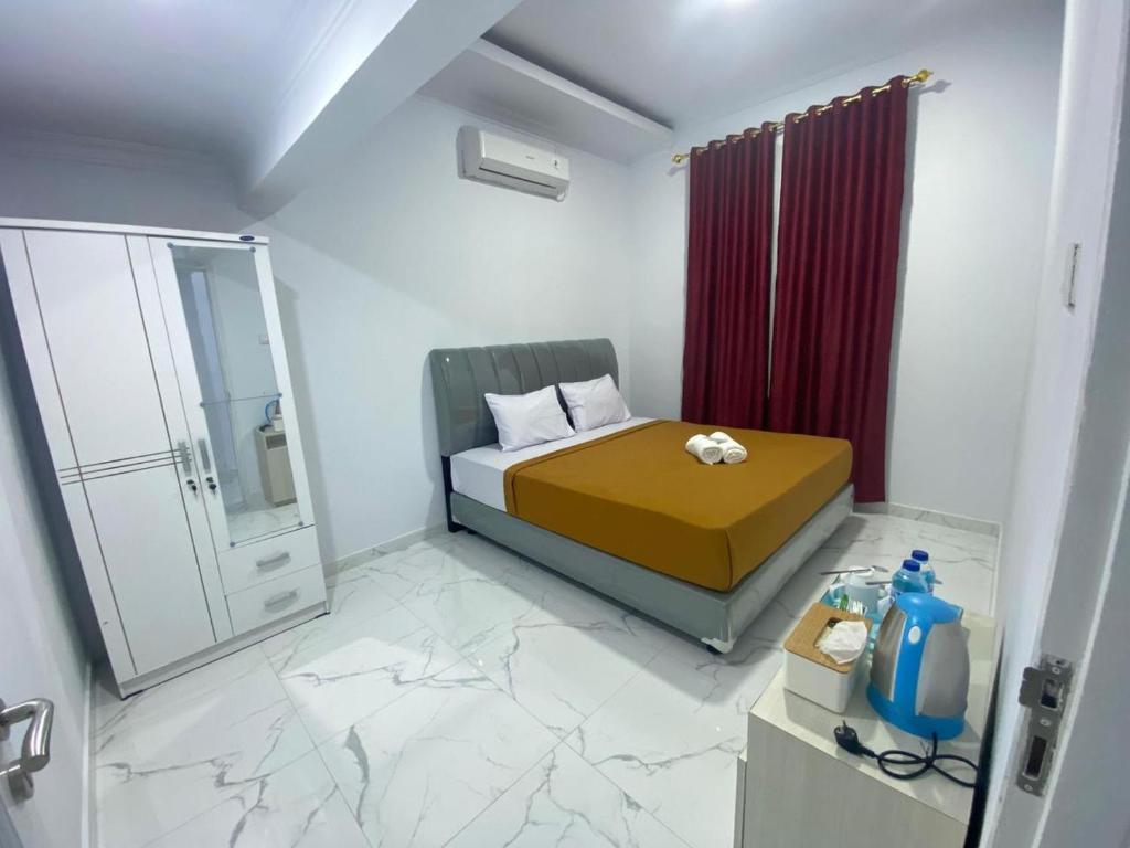 a small bedroom with a bed and a shower at Sima El Barkah in Padang
