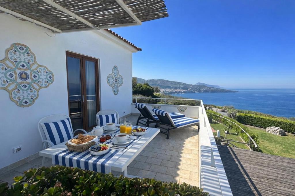 a table on a balcony with a view of the ocean at Villa Raf in Vico Equense