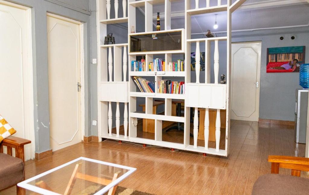 a living room with a book shelf filled with books at Inuka Guest house in Nairobi