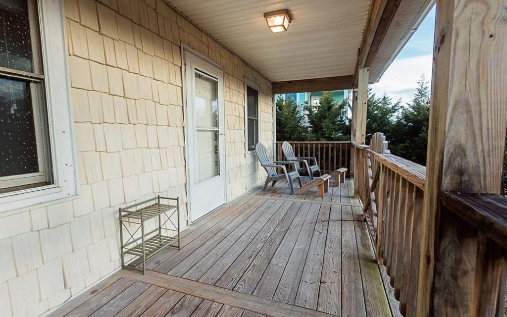 a porch of a house with two chairs on it at Central OBX Getaway with Pool and Sound Access in Nags Head