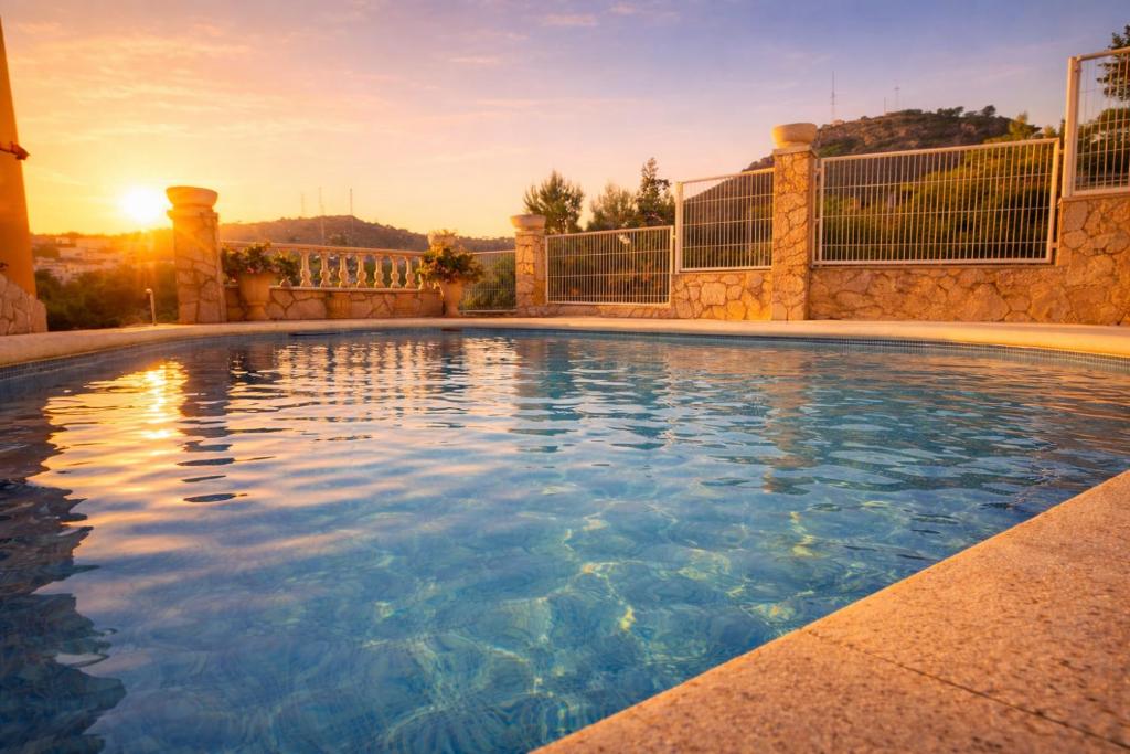a swimming pool with the sun setting in the background at VIP private Poolsuite Calafell in Calafell