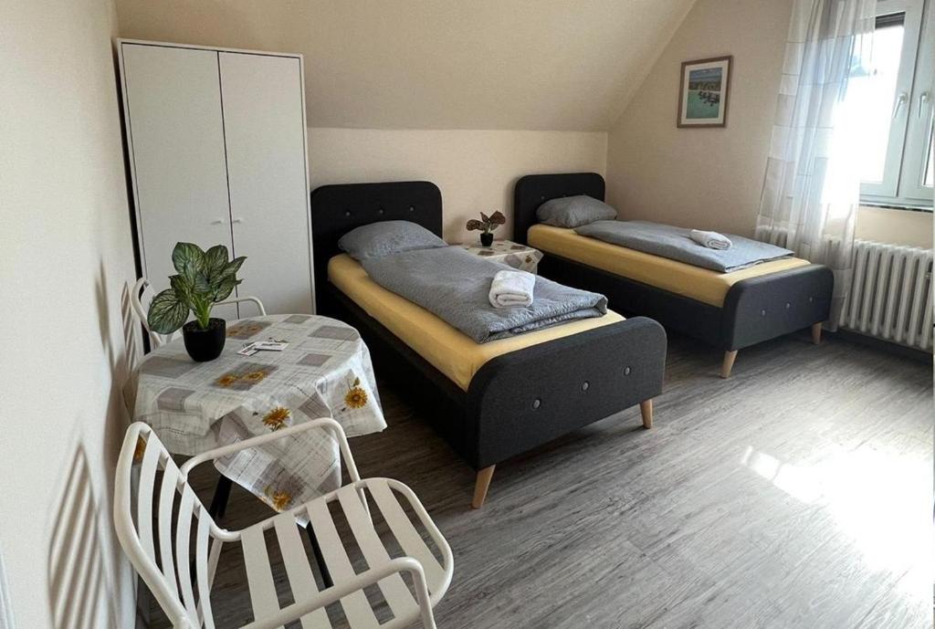 a small room with two beds and a table at Pension Highway - Löhne Löhner Straße 111 in Löhne