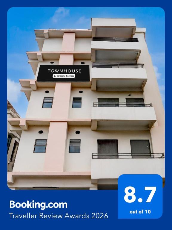 a tall building with a sign on it at Townhouse Beltola Tiniali Formerly Hotel Pratishtha in Guwahati