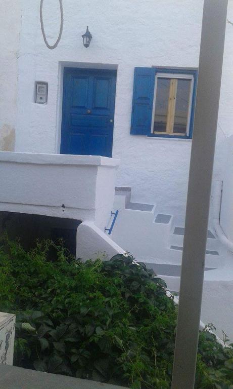 a white building with a blue door and stairs at Studio Katerina in Kimolos