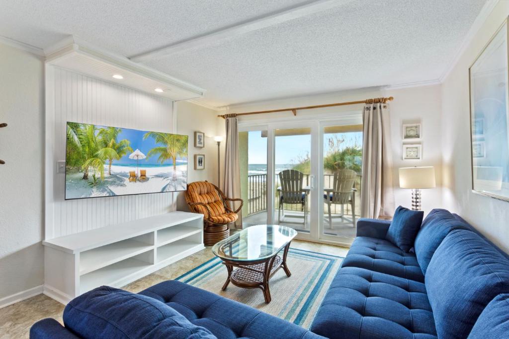 a living room with a blue couch and a table at DL104 - Dune's Watch in Nags Head