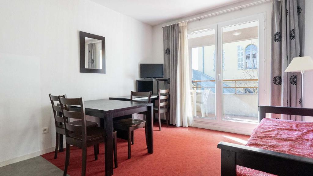 a dining room with a table and chairs and a window at Virginia N309 2P4 in Grasse