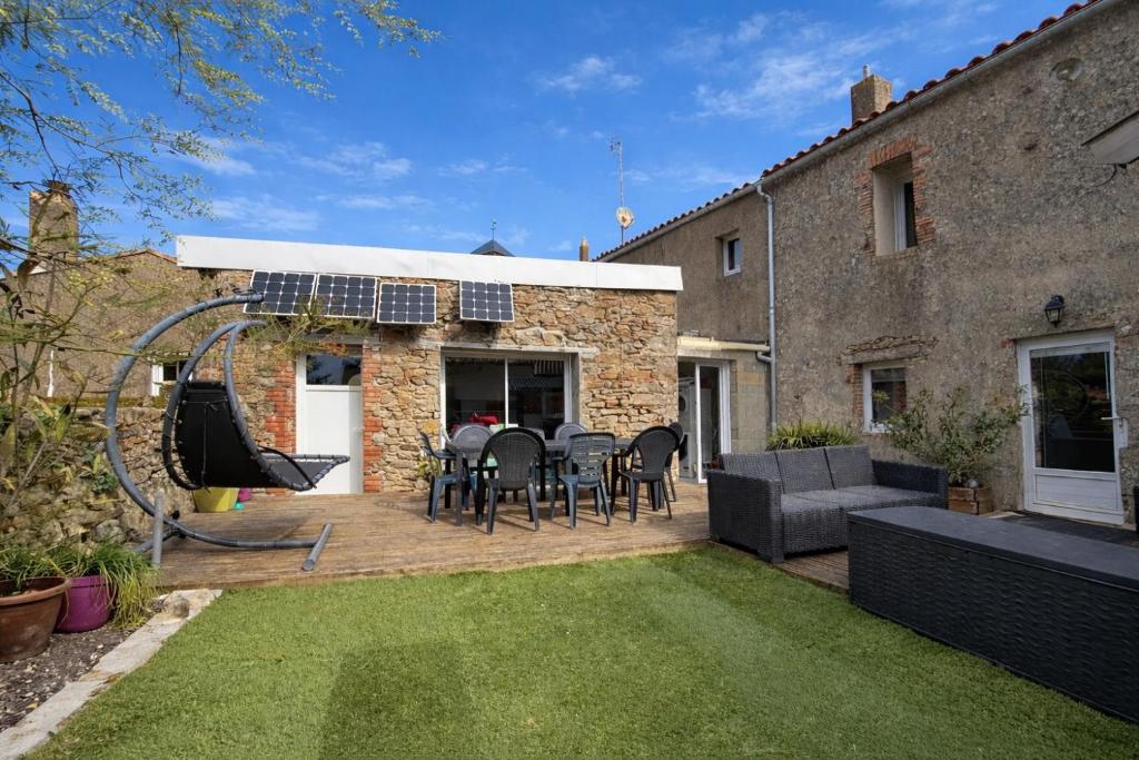 a patio with a table and chairs in a yard at Le repos beaurepairien in Beaurepaire