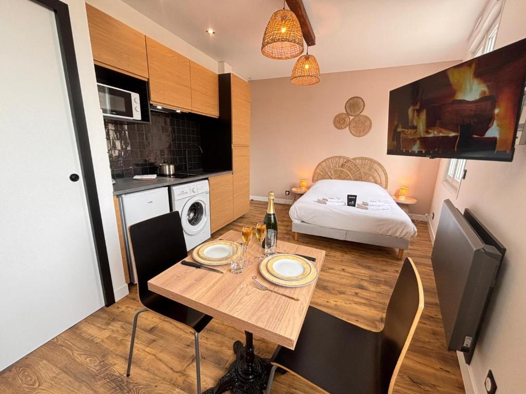 a small apartment with a dining table and a bed at 2 Neufchâtel studio agréable et cosy tout équipé in Reims