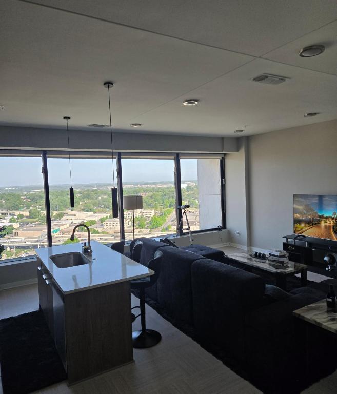 a living room with a couch and a tv at Immaculate Vibes Sunset View Condo in Birmingham