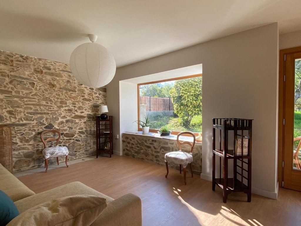 a living room with a couch and chairs and a window at Casa Lambre in Paderne