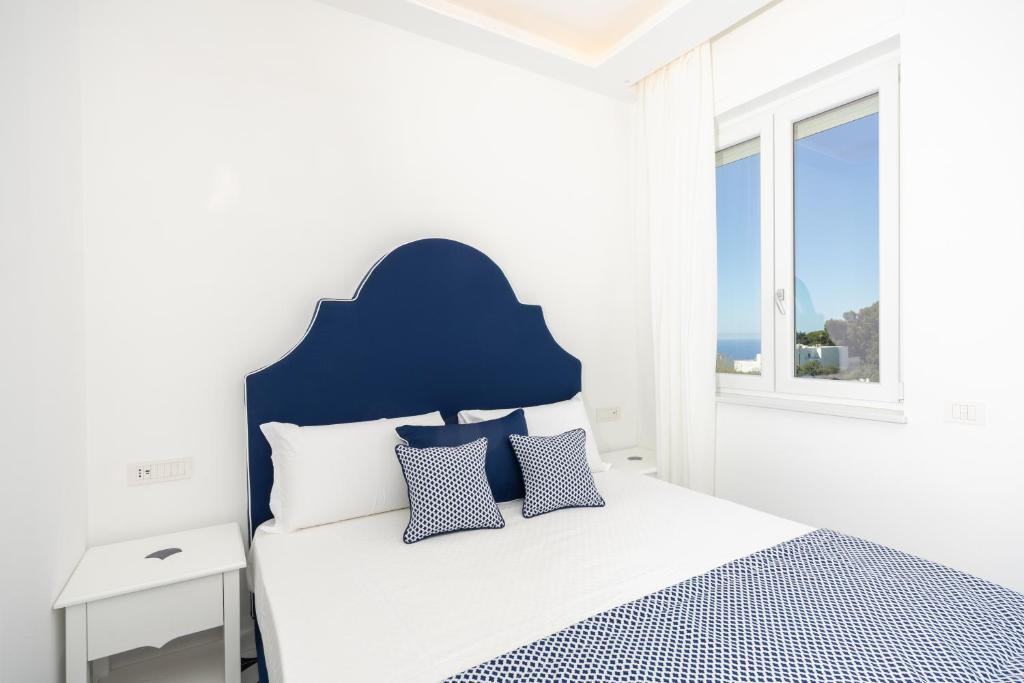 a bedroom with a bed with a blue headboard at Palazzo Sant'Elena in Anacapri