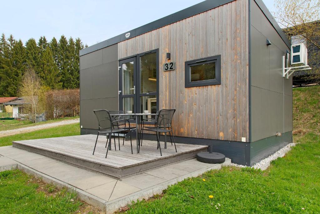 a tiny house with a table and chairs on a deck at Tinyhouse Entspannung und Erholung in Untergriesbach