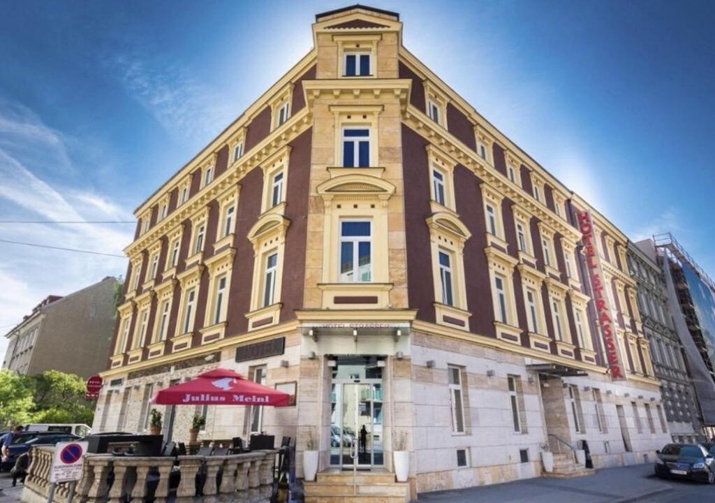 ein großes Gebäude mit einem roten Regenschirm davor in der Unterkunft Hotel Strasser in Graz