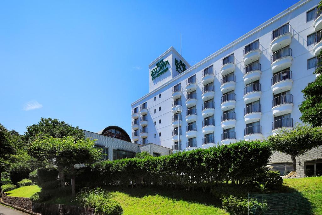 a hotel with a hedge in front of it at Resorpia Kumihama in Kyotango