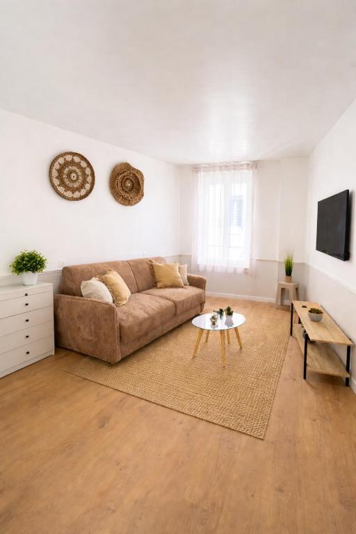 a living room with a couch and a table at L'échappée belle, en Champagne in Dormans