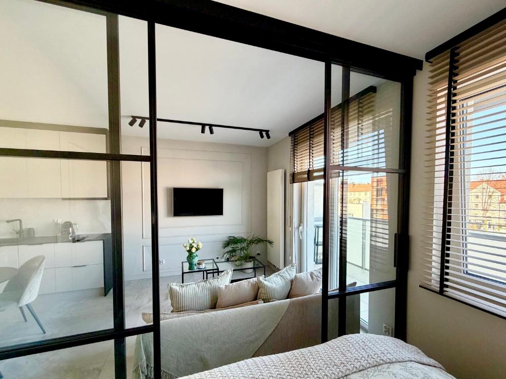 a bedroom with a couch and a living room at Apartamant Oaza II in Koszalin