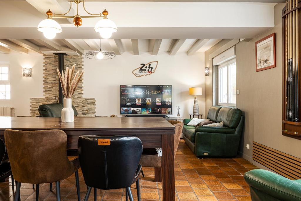 a living room with a table and a couch at À 300m du virage de Mulsanne - Maison 8 pers avec extérieur et parking in Mulsanne