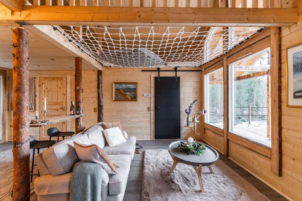 a living room with a couch and a table at Tupa Lodge by The Guide Father in Rovaniemi