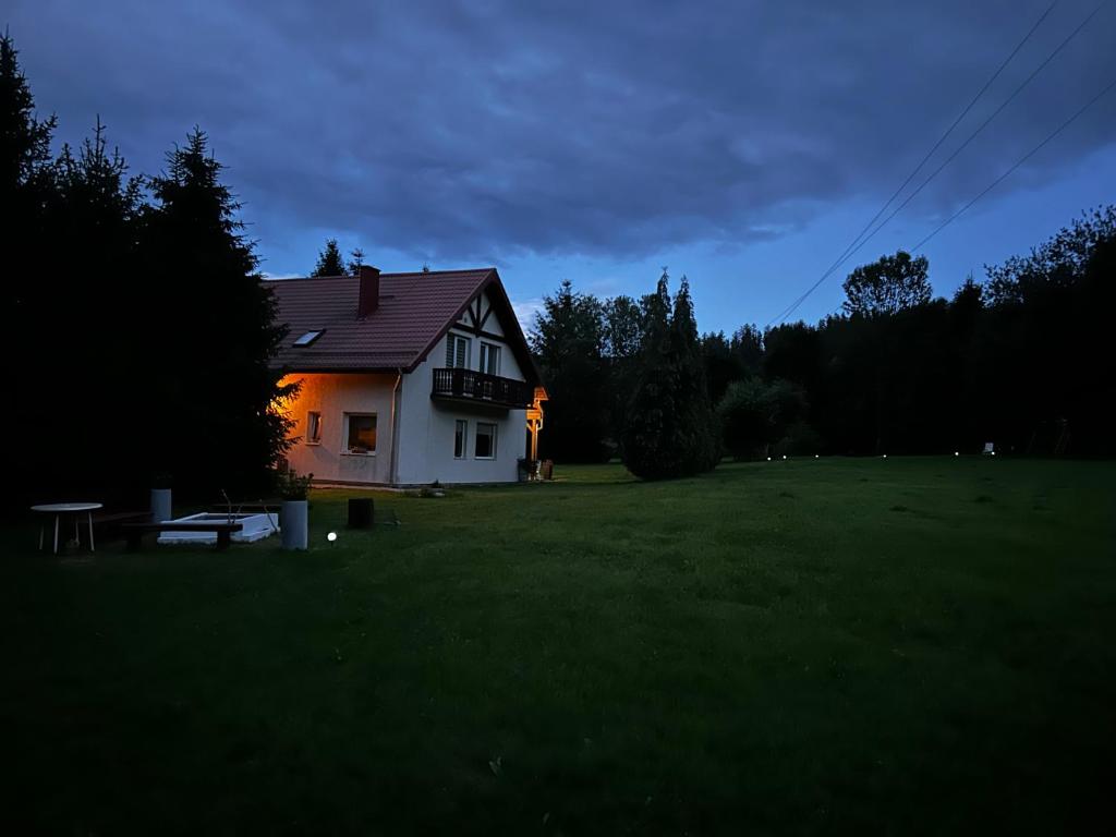 a house in the middle of a field at night at Villa van Dam in Miłków