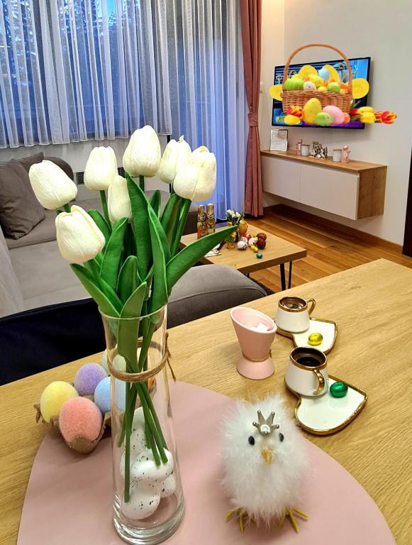 a vase filled with white flowers sitting on a table at Oasis Titova vila in Palisat