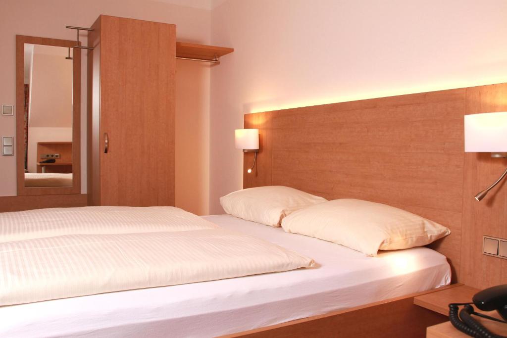 Postel nebo postele na pokoji v ubytování Hotel Goldenes Fass in Rothenburg ob der Tauber