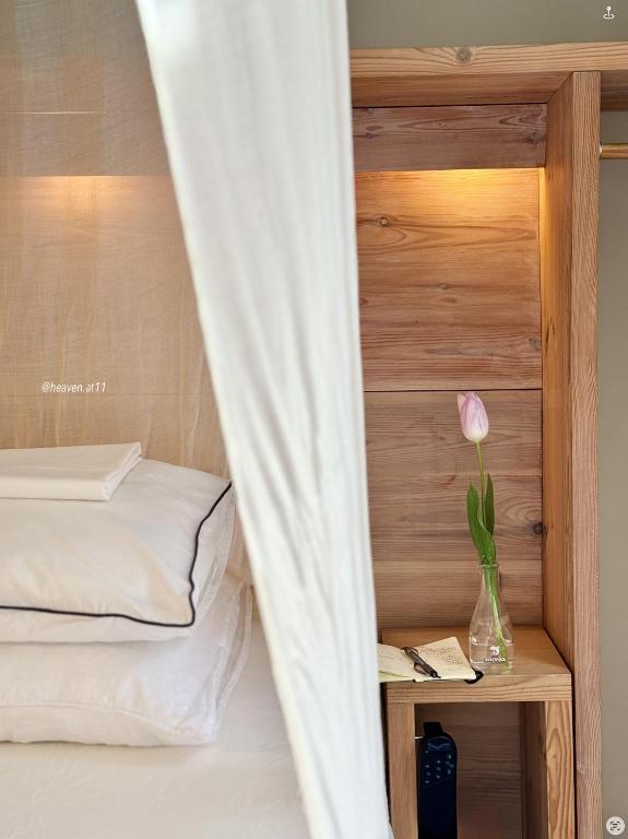 a bed with a vase with a flower in it at Heaven AT 11, your Deluxe Studio with personal bathroom, kitchenette & terrace in Ghent