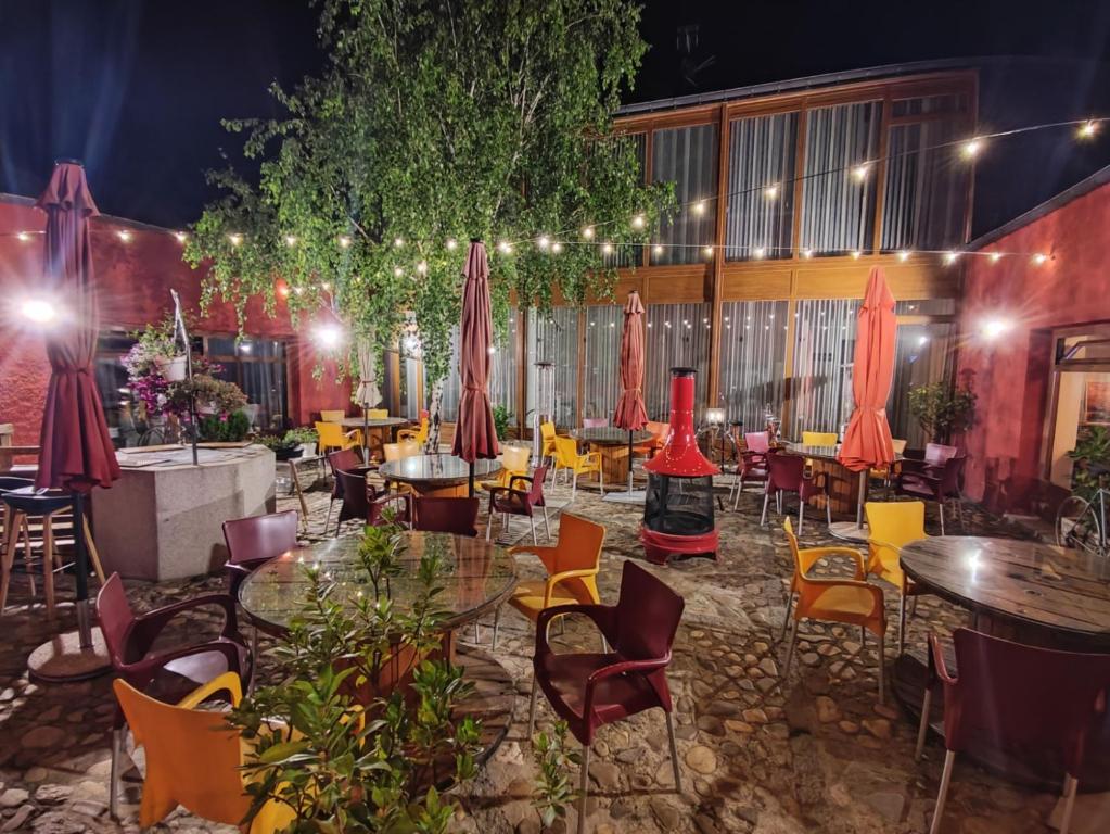 a restaurant with tables and chairs and red umbrellas at CicloLodge in Lozoya