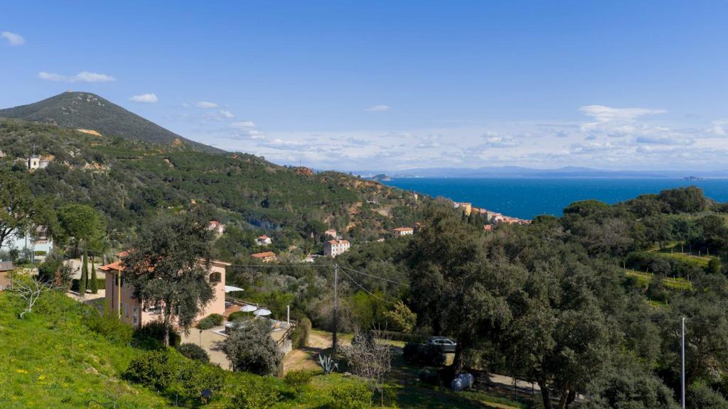 a village on a hill with the ocean in the background at VILLA PERELLE 8, Emma Villas in Rio nellʼElba
