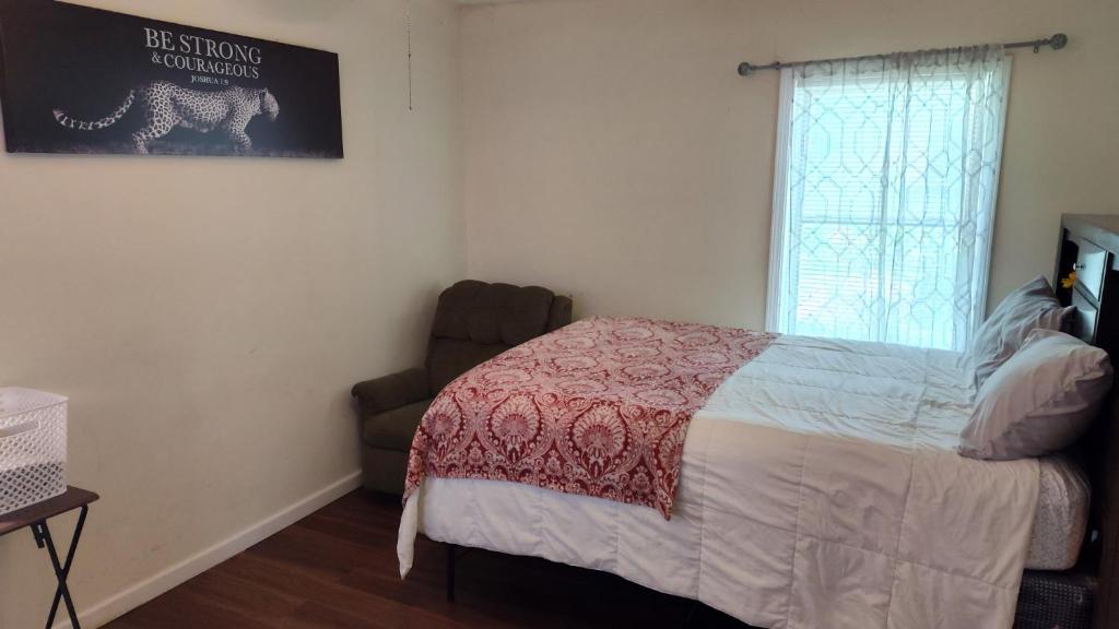 a bedroom with a bed and a chair and a window at McAfee Private Room Shared Bathroom 1 in Decatur