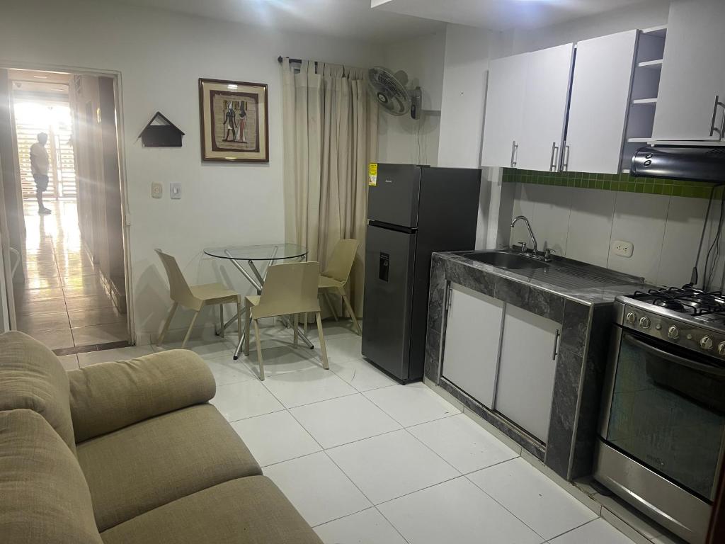 a kitchen and living room with a couch and a table at Estudio 1 Cerca PLAYA Y CENTRO HISTORICO in Santa Marta