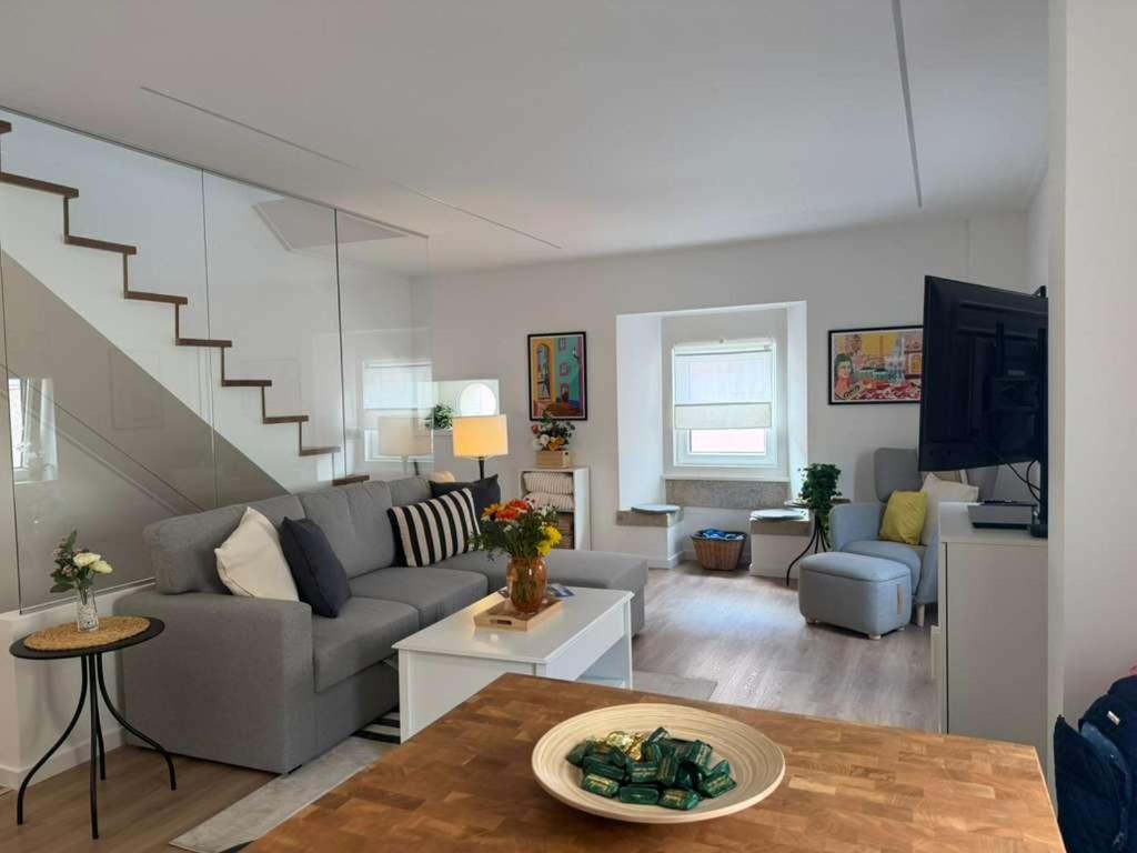 a living room with a couch and a staircase at Casa de Saudade - Refúgio junto ao mar in Paço de Arcos