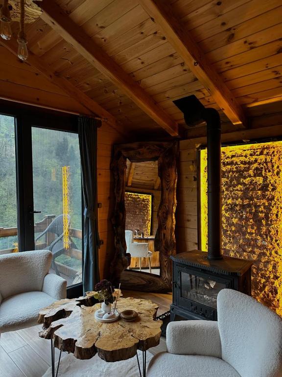a living room with a fireplace and a table at Maysa Suit Bungalov in Çamlıhemşin