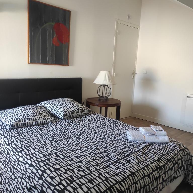 a bedroom with a bed with two towels on it at Grand T2 climatisé très calme in Périgueux