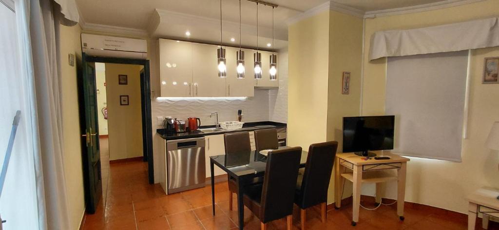 a kitchen and dining room with a table and chairs at Apartamento Parque dos Reis I in Monte Gordo