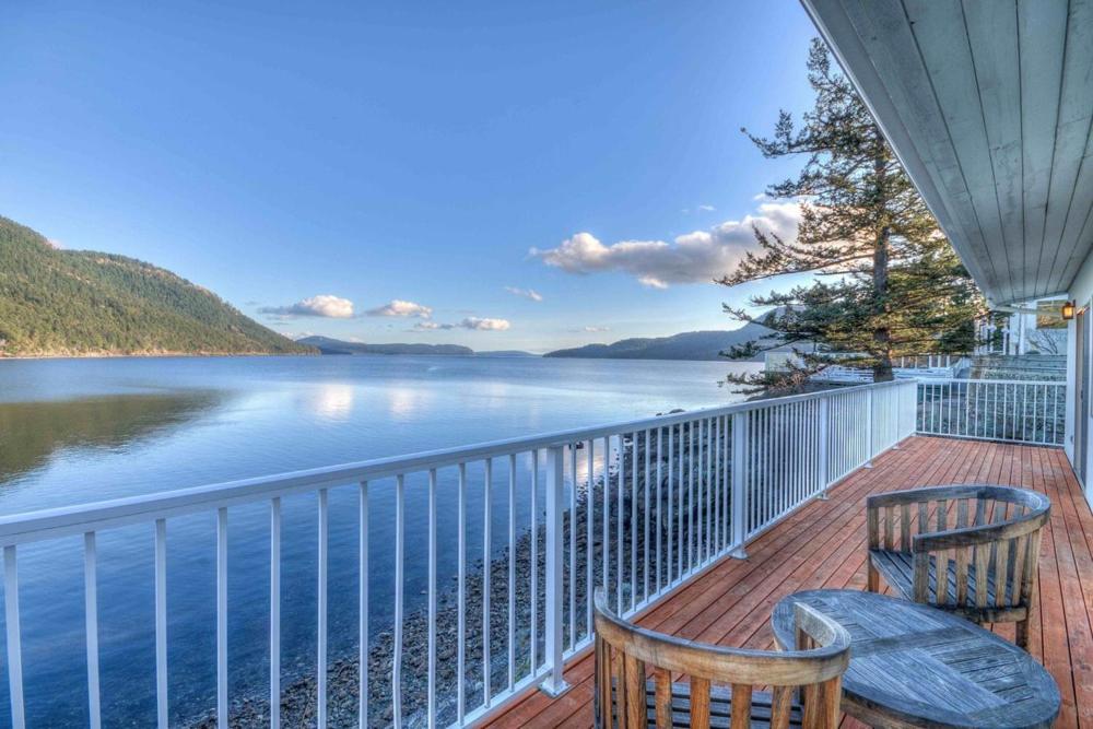 a balcony with two chairs and a view of a lake at Rosario Resort in Eastsound