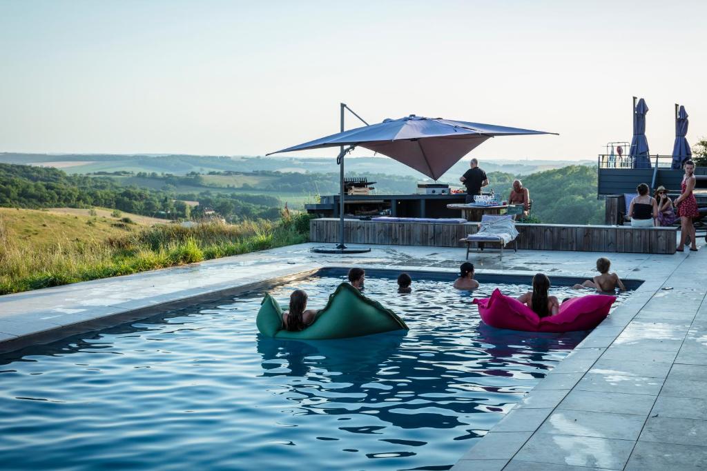 a group of people swimming in a swimming pool at Hitton Séjours Nature in Biran